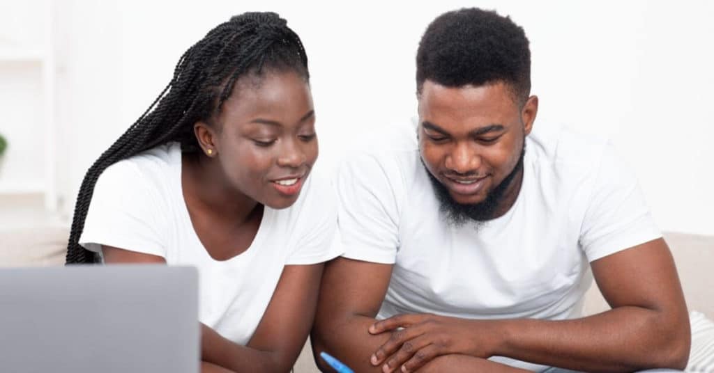 A young black couple are going over a inventory list