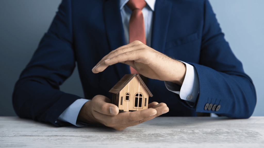 businessman holds a house in his hand; business concept