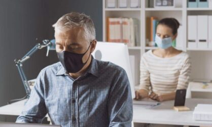 Two office coworkers are working within an office space with face masks on business interruption