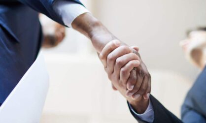 Two people are shaking hands over a public adjuster insurance claim