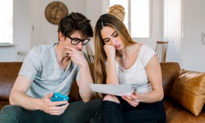 A young couple are going over their rejection letter from their insurance company