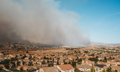 California neighborhood with wildfire smoke in background